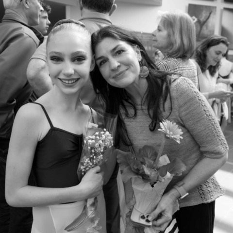 Mother giving ballet daughter flowers.